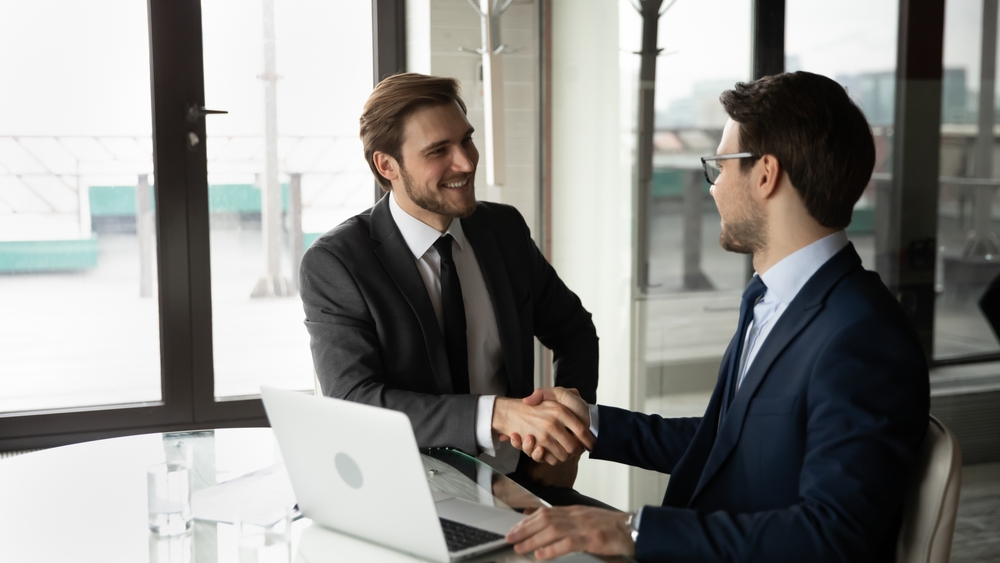 Wide,Banner,View,Of,Smiling,Businessmen,Shake,Hands,Close,Deal