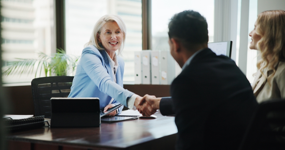 Business,,Woman,And,Handshake,With,Couple,In,Office,For,Finance